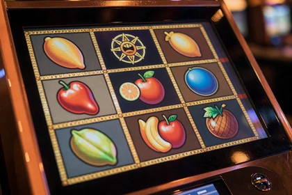 Gl&uuml;hender Slot-Automaten-Bildschirm mit bunten Symbolen im Vox Casino